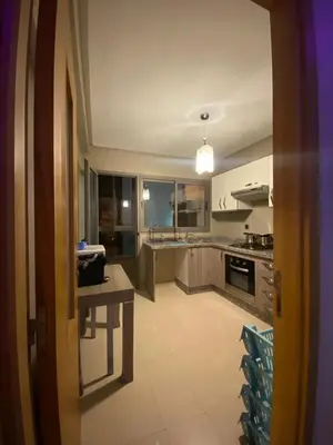 a large kitchen with a table and chairs in it at Appartement sur SIDI Rahal in Casablanca