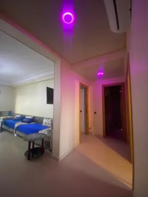 a bedroom with purple lights and a bed and a mirror at Appartement sur SIDI Rahal in Casablanca