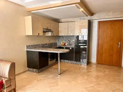 a kitchen with a table and a black refrigerator at Studio Cosy Centre Ville Casablanca in Casablanca