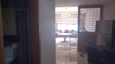 a view of a living room and a kitchen with a refrigerator at Résidence Mansbay Rosa, Mohammedia in Mohammedia