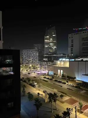 a city at night with cars parked on a street at Tour 33 : Appartement chic en plein cœur de Casa in Casablanca