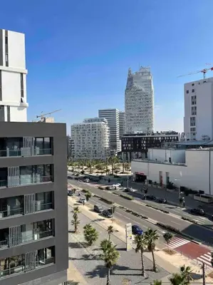 a city with tall buildings and a street with palm trees at Tour 33 : Appartement chic en plein cœur de Casa in Casablanca