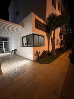 a building with a palm tree in front of it at ZS house harhoura vue sur piscine in Temara