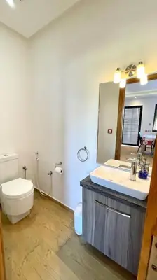 a bathroom with a toilet and a sink and a mirror at Villa Havre De Paix à Casablanca in Casablanca