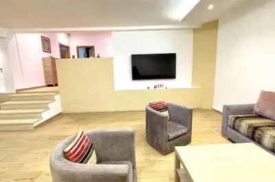 a living room with two chairs and a flat screen tv at Villa Havre De Paix à Casablanca in Casablanca