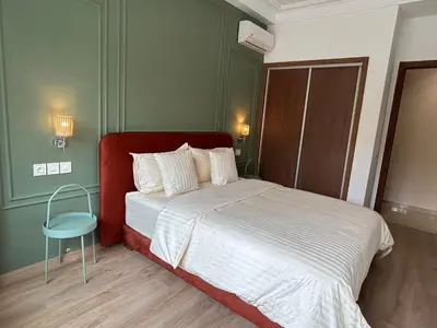 a bedroom with a bed and a blue chair at Studio cosy chic in Casablanca