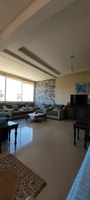 a large living room with couches and tables at Bel appartement avec vue sur mer Sidi Rahal in Sidi Rahal