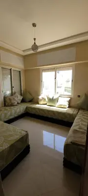 a room with two beds and two windows at Bel appartement avec vue sur mer Sidi Rahal in Sidi Rahal