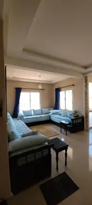 a living room with a couch and a table at Bel appartement avec vue sur mer Sidi Rahal in Sidi Rahal