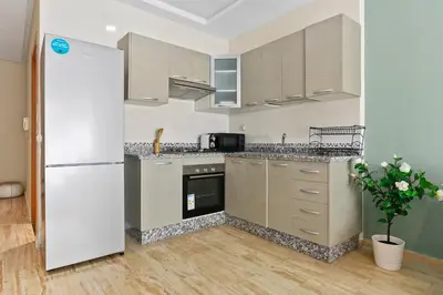 a kitchen with a refrigerator and a stove top oven at Serene One Bed Oasis in the Heart Of The Medina in Les Camps