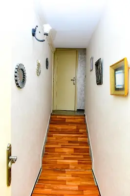 a hallway with wooden floors and a yellow door at Dar Lamine Duplex in Rabat