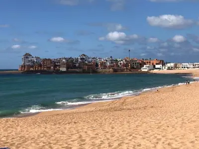 a view of a beach with buildings in the background at Jolie Appartement 2 chambres / vue piscine in Bouznika