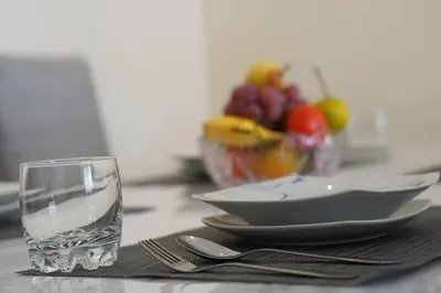 a glass of water sitting next to a plate of food at Jolie Appartement 2 chambres / vue piscine in Bouznika