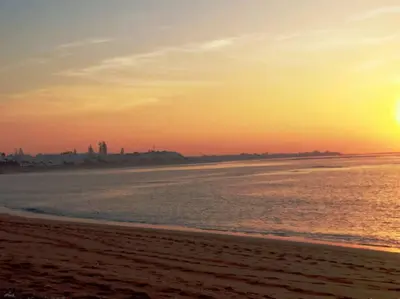 a sunset on a beach with the ocean at Jolie Appartement 2 chambres / vue piscine in Bouznika