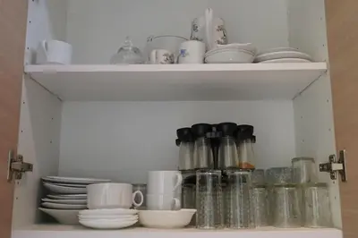 a cabinet filled with dishes and cups and plates at Jolie Appartement 2 chambres / vue piscine in Bouznika