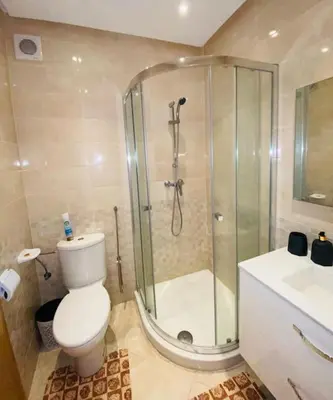 a bathroom with a shower and a toilet and a sink at Jolie Appartement 2 chambres / vue piscine in Bouznika