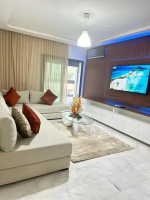 a living room with a couch and a tv at Appartement confortable au corniche in Mohammedia