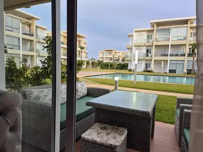 a patio with a table and chairs next to a pool at CASA BAY BEACH OMK 3 in Sidi Rahal