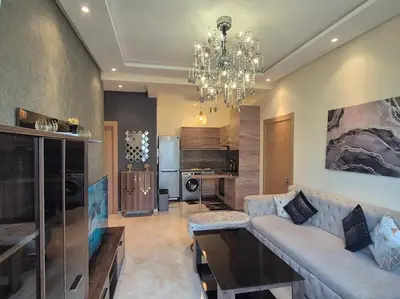 a living room with a couch and a chandelier at CASA BAY BEACH OMK 3 in Sidi Rahal
