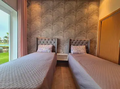 two beds sitting next to each other in a bedroom at CASA BAY BEACH OMK 3 in Sidi Rahal