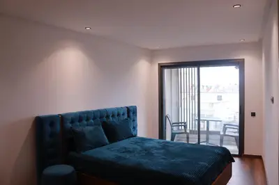a bedroom with a blue bed with a balcony at LUXE APPARTEMENT in Casablanca