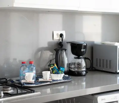 a kitchen counter top with a coffee maker and cups at Two bedrooms sunny appartement in ain diab in Casablanca