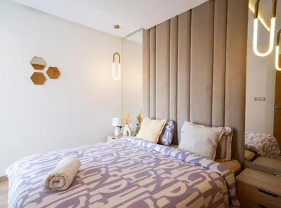 a bedroom with a large bed with a large headboard at Two bedrooms sunny appartement in ain diab in Casablanca
