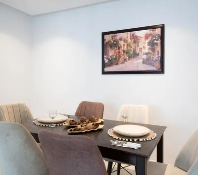 a dining room table with chairs and a painting on the wall at Two bedrooms sunny appartement in ain diab in Casablanca