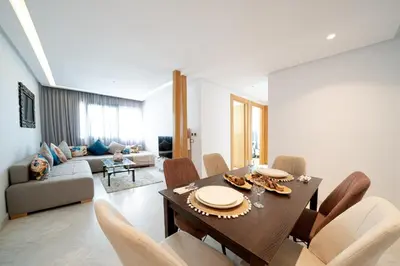 a living room with a dining table and chairs at Two bedrooms sunny appartement in ain diab in Casablanca