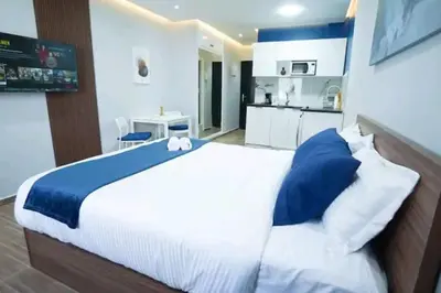 a bedroom with a large bed and a kitchen at Luxury Studio, Coeur de l'Agdal in Rabat