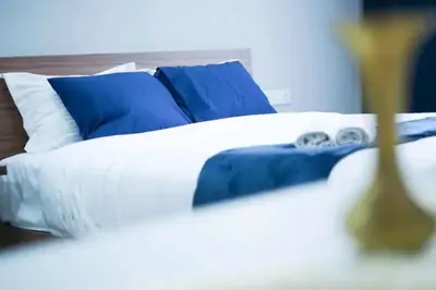 a bed with blue and white pillows in a room at Luxury Studio, Coeur de l'Agdal in Rabat
