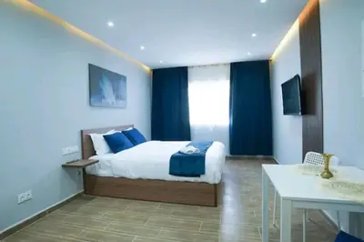 a bedroom with a king sized bed and a table at Luxury Studio, Coeur de l'Agdal in Rabat