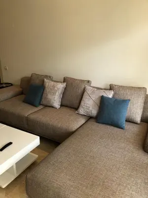 a living room with a couch with pillows on it at Appartement moderne CASABAY BEACH Sidi Rahal in Sidi Rahal