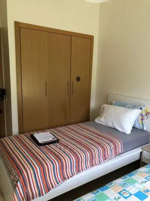 a bedroom with a bed with a wooden cabinet at Appartement moderne CASABAY BEACH Sidi Rahal in Sidi Rahal