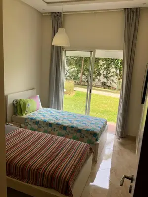 a bedroom with a bed and a large window at Appartement moderne CASABAY BEACH Sidi Rahal in Sidi Rahal