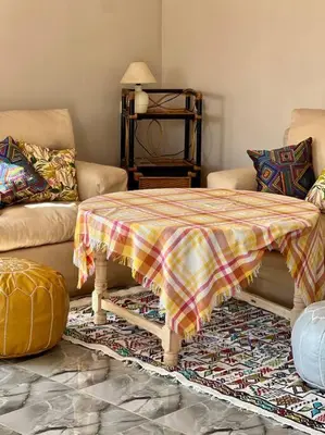 a living room with a table and a couch at La Casa Blanca • Ecolodge Vert in Oulad Youssef