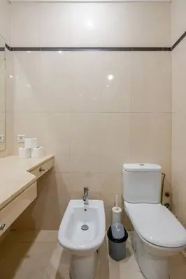 a white bathroom with a toilet and a sink at TT Holidays 3BR Racine Casablanca in Casablanca