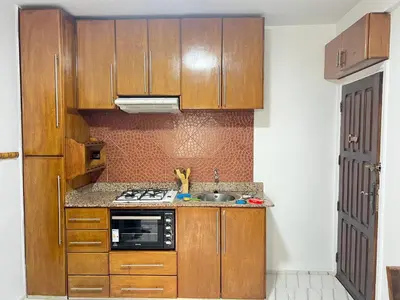 a kitchen with wooden cabinets and a stove top oven at Studio la corniche in Rabat