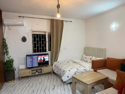 a living room with a bed and a television at Studio la corniche in Rabat