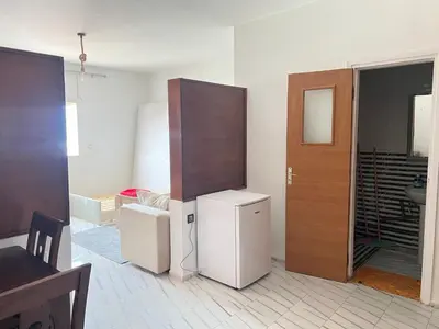 a room with a refrigerator and a wooden door at Studio la corniche in Rabat