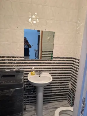 a man taking a picture of a bathroom with a sink at Studio la corniche in Rabat