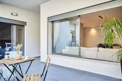 a patio with a table and chairs in front of a window at Modern Elegance 3 Bed Escape in Trendy Casablanca in Casablanca