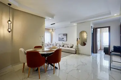 a living room with a table and chairs and a couch at Your Home Away from Home 2 Bed Flat With Parking in Casablanca
