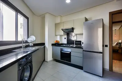 a kitchen with a refrigerator and a sink and a dishwasher at Your Home Away from Home 2 Bed Flat With Parking in Casablanca
