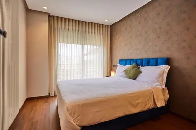 a bedroom with a bed with a blue headboard and a window at Discover Casablanca Stay in our 3-Bed Gem with Parking in Casablanca