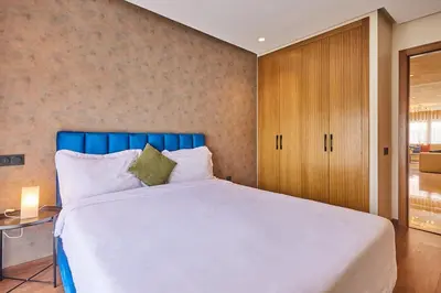 a bedroom with a large bed with a blue headboard at Discover Casablanca Stay in our 3-Bed Gem with Parking in Casablanca