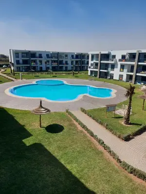 an overhead view of a swimming pool in front of a building at Dahlia Sidi rahal in Sidi Rahal