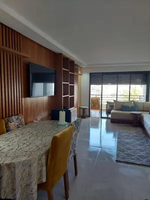 a dining room with a table and a living room at Dahlia Sidi rahal in Sidi Rahal