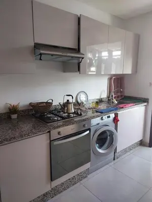 a kitchen with a stove and a washing machine at Dahlia Sidi rahal in Sidi Rahal