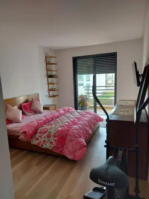 a bedroom with a bed with pink sheets and a window at Dahlia Sidi rahal in Sidi Rahal